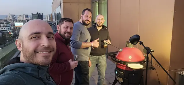 Four colleagues taking a selfie by the grill on the office terrace